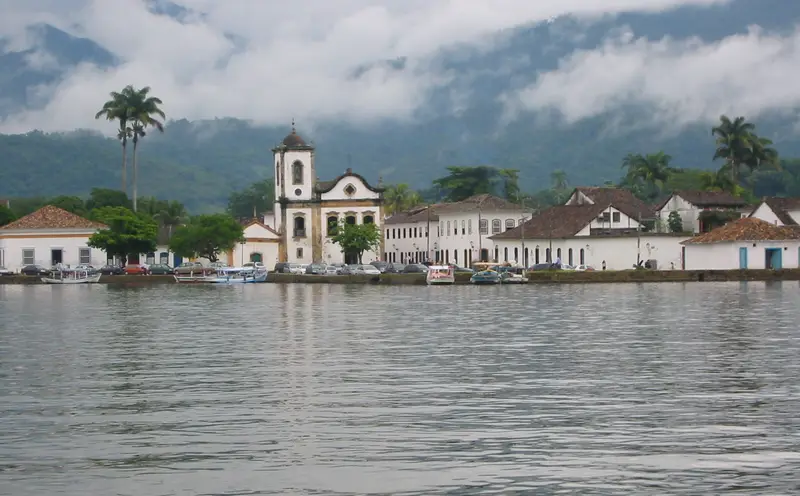 Rua de pedras do centro histórico de Paraty com casario colonial branco e portas coloridas